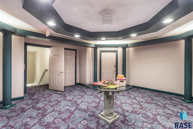 cinema room with carpet, a raised ceiling, and ornate columns