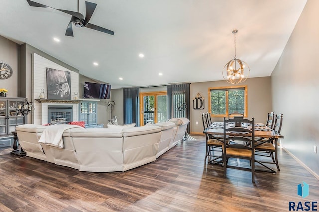 living room with ceiling fan with notable chandelier, lofted ceiling, and hardwood / wood-style floors