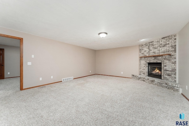 unfurnished living room featuring a textured ceiling, carpet flooring, and a brick fireplace