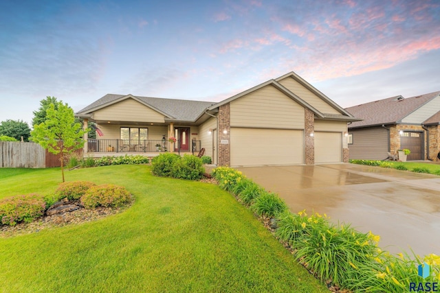 view of front of house with a garage, a porch, and a lawn