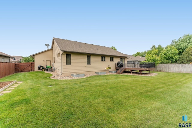 back of property featuring a wooden deck and a lawn