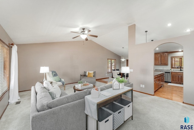 carpeted living room featuring lofted ceiling, sink, and ceiling fan