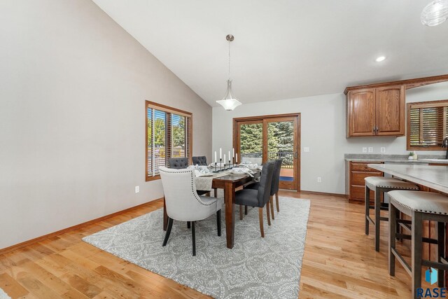 dining room featuring light hardwood / wood-style flooring and vaulted ceiling