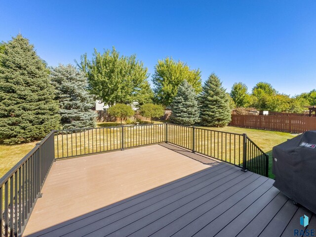 deck with a lawn and area for grilling