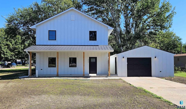 modern farmhouse style home with a garage, an outdoor structure, a front lawn, and covered porch