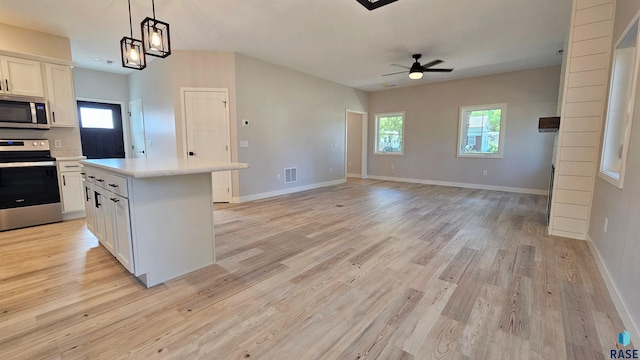 kitchen with white cabinetry, ceiling fan, stainless steel appliances, and a wealth of natural light