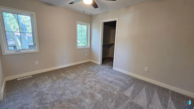 carpeted spare room with ceiling fan