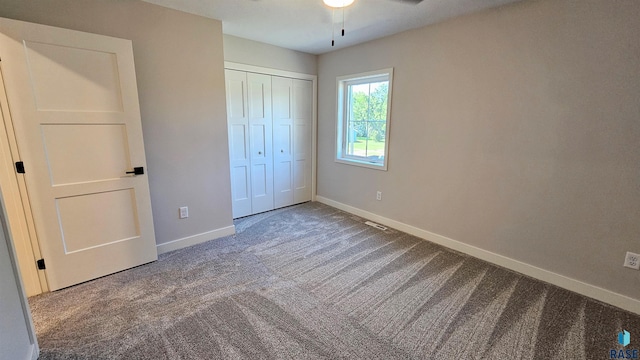 unfurnished bedroom with carpet floors, ceiling fan, and a closet