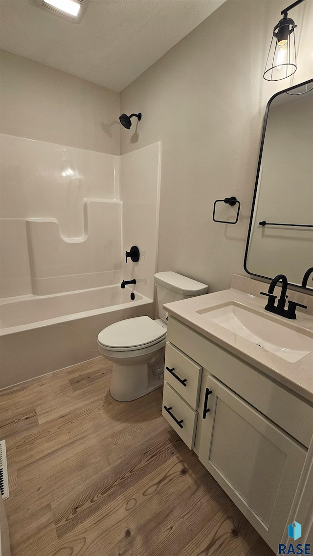 full bathroom featuring bathing tub / shower combination, vanity, toilet, and hardwood / wood-style floors