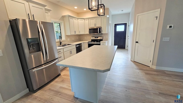 kitchen with plenty of natural light, a center island, stainless steel appliances, and decorative light fixtures