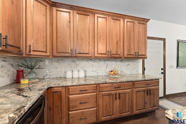 kitchen featuring dishwasher, dark hardwood / wood-style floors, stone countertops, and tasteful backsplash