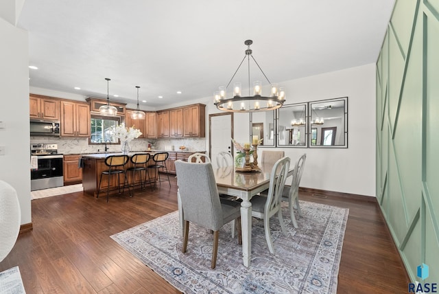 dining area featuring an inviting chandelier, dark hardwood / wood-style floors, and sink