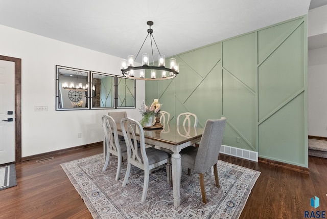 dining area featuring a notable chandelier and dark wood-type flooring