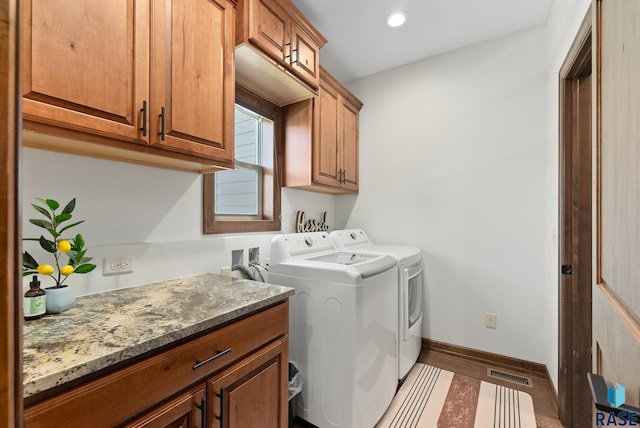 laundry room featuring cabinets, separate washer and dryer, and hardwood / wood-style flooring