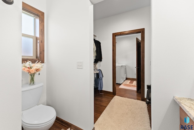 bathroom with vanity, hardwood / wood-style floors, toilet, and washing machine and clothes dryer