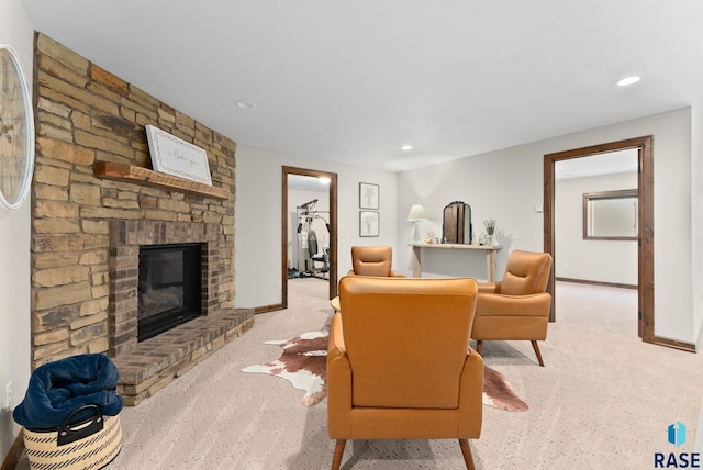 living room featuring light carpet and a stone fireplace