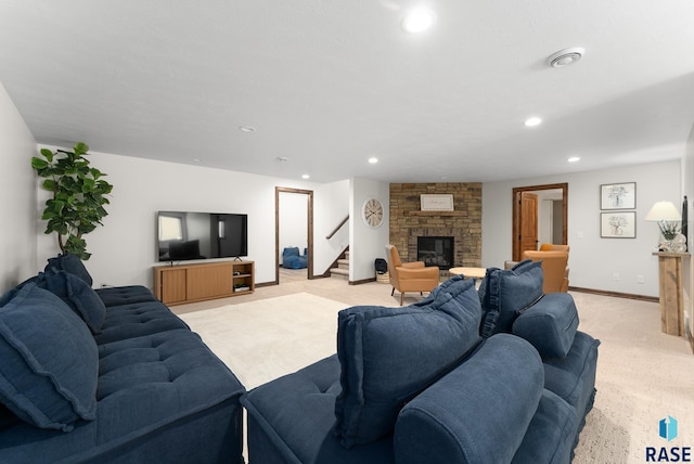 living room with a stone fireplace and light colored carpet