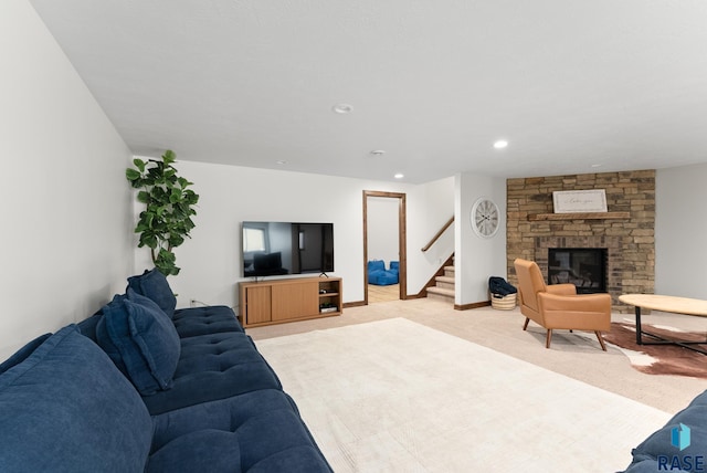 living room featuring a stone fireplace and light carpet