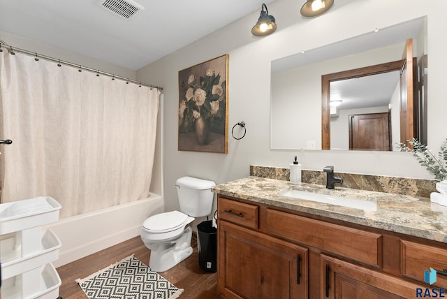 full bathroom with shower / bath combo with shower curtain, hardwood / wood-style flooring, vanity, and toilet