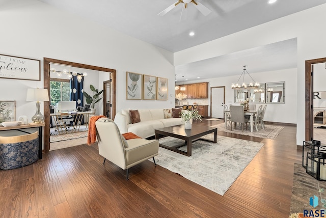 living room with ceiling fan with notable chandelier and dark wood-type flooring