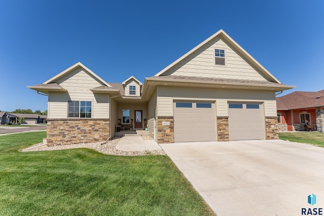 craftsman inspired home with a garage and a front lawn