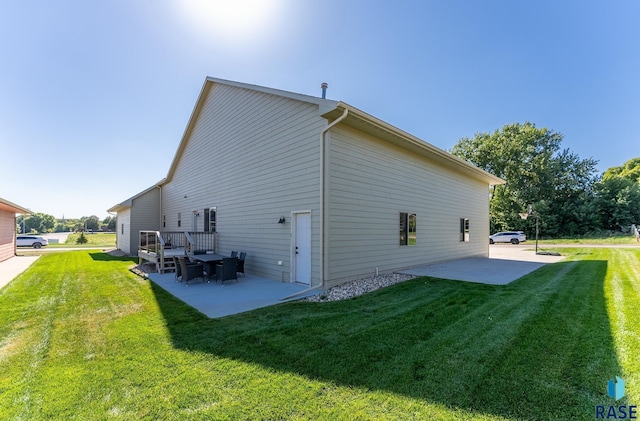 rear view of property featuring a yard and a patio area