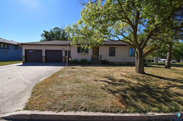 ranch-style house featuring a garage and a front lawn