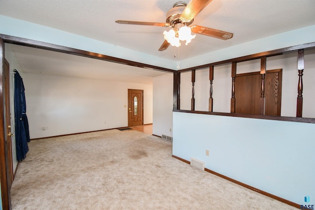 carpeted empty room featuring a textured ceiling and ceiling fan