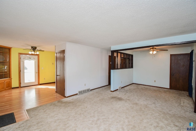 interior space featuring ceiling fan, a textured ceiling, and light wood-type flooring