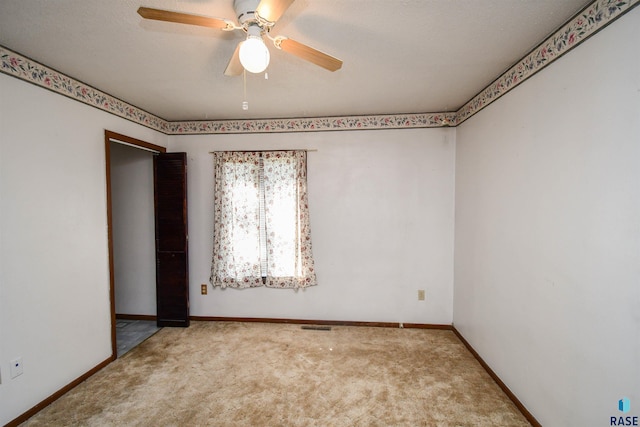 carpeted spare room featuring a textured ceiling and ceiling fan