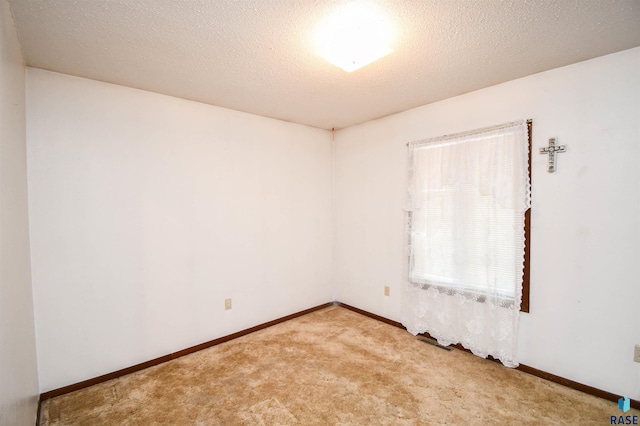 carpeted spare room featuring a textured ceiling