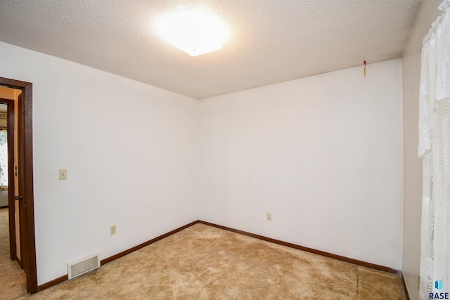 carpeted spare room with a textured ceiling