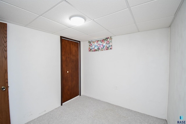 carpeted spare room with a paneled ceiling