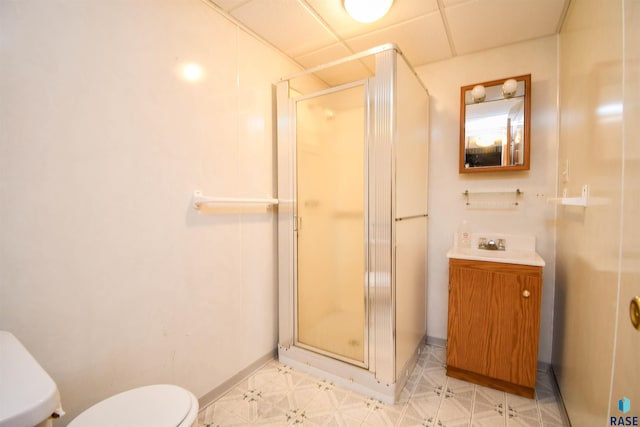 bathroom featuring vanity, a paneled ceiling, toilet, and an enclosed shower