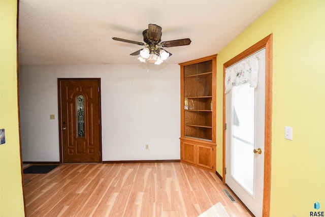 foyer entrance with ceiling fan and light hardwood / wood-style floors