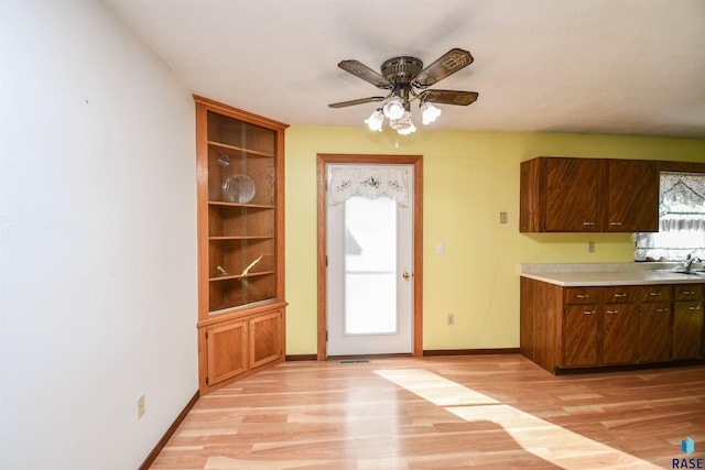 interior space with ceiling fan, sink, and light hardwood / wood-style floors