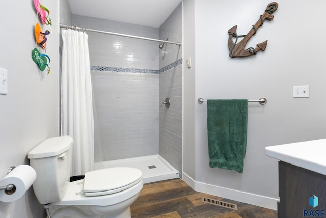 bathroom with wood-type flooring, a shower with curtain, vanity, and toilet