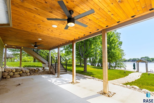 view of patio / terrace with ceiling fan and a water view