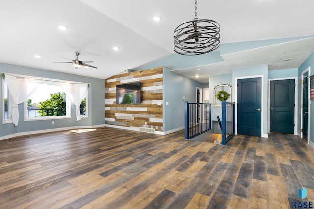 unfurnished living room with ceiling fan, dark wood-type flooring, and vaulted ceiling