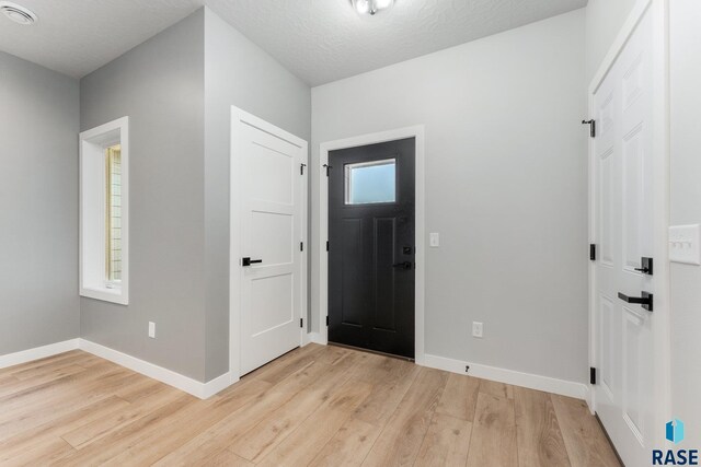 entrance foyer featuring light hardwood / wood-style floors and a textured ceiling