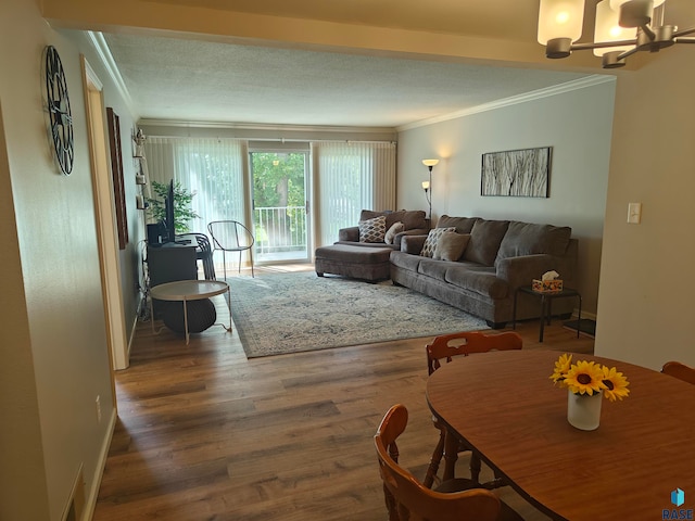 living room with ornamental molding, a chandelier, and dark wood-type flooring