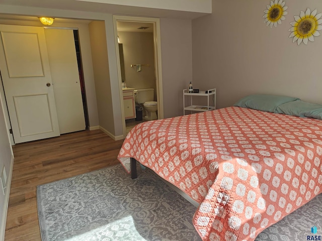 bedroom featuring ensuite bath and hardwood / wood-style flooring