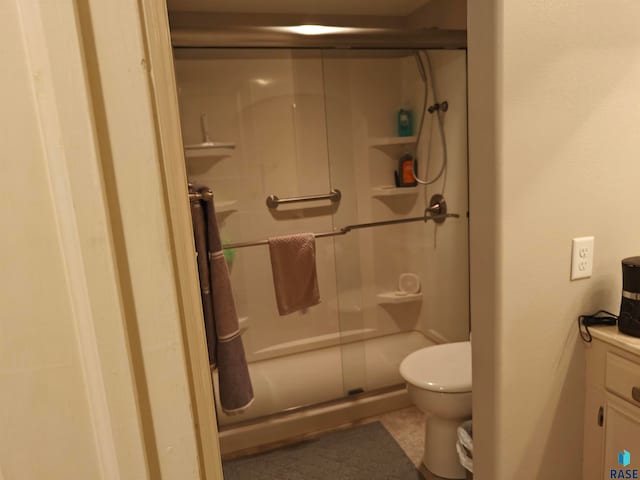 bathroom featuring vanity, tile patterned floors, a shower with shower door, and toilet