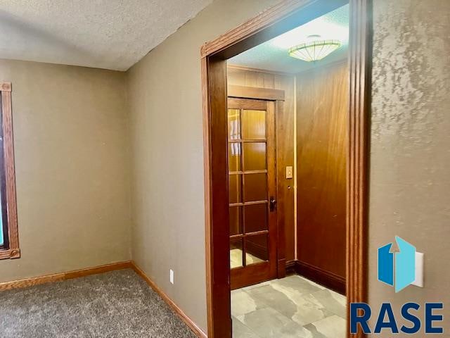 entryway featuring a textured ceiling and carpet flooring