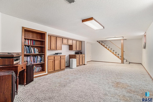 interior space with a textured ceiling and light colored carpet