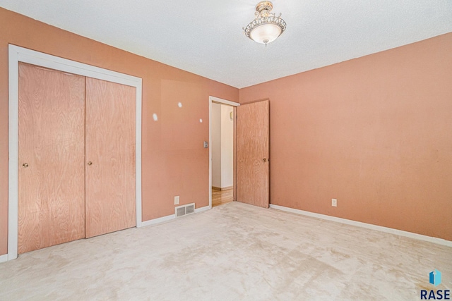 unfurnished bedroom with a textured ceiling, a closet, and carpet flooring