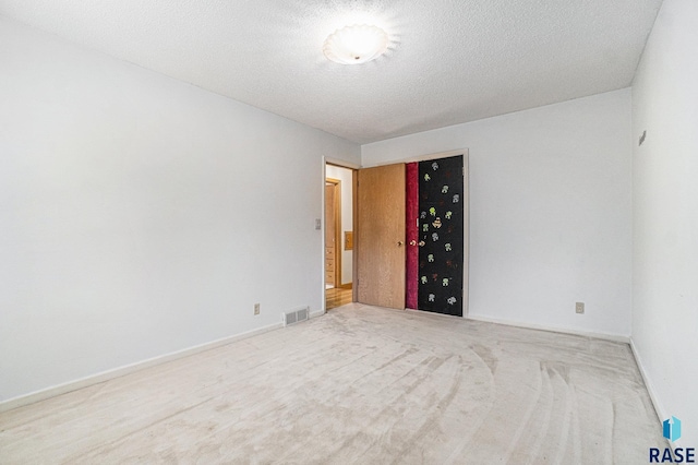 carpeted spare room featuring a textured ceiling