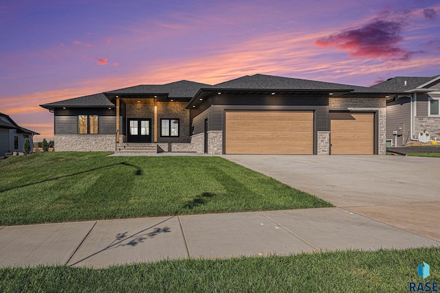 prairie-style house featuring a yard and a garage