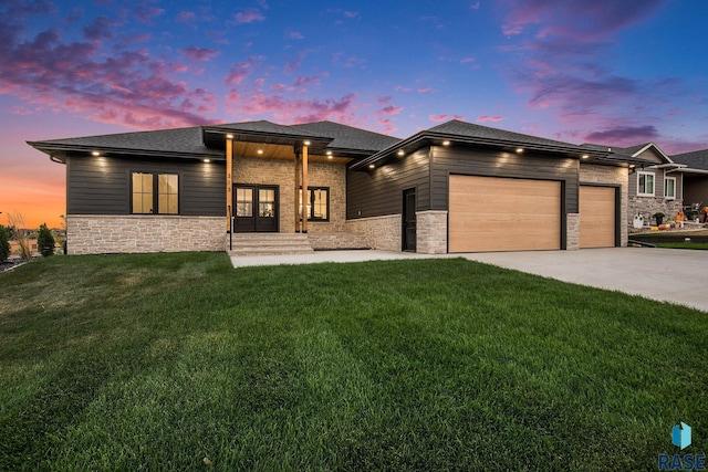 313 Red Spruce Ave, Sioux Falls, SD 57110 - prairie-style house with a garage, a lawn, a shingled roof, stone siding, and driveway