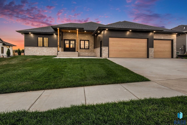 313 Red Spruce Ave, Sioux Falls, SD 57110 - prairie-style house with an attached garage, driveway, a front yard, and stone siding